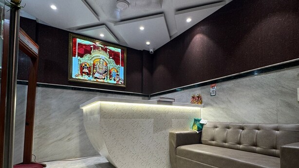 Un interior moderno con un mostrador de recepción curvo, un sofá y una ventana de vitral.