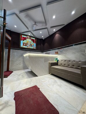 A modern interior with a curved reception desk, a sofa, and a stained glass window.