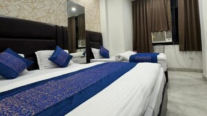 Habitación de hotel con una cama grande, ventilador de techo, aire acondicionado instalado en la pared y ventana con cortinas.