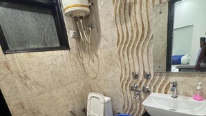 Un baño con inodoro, lavamanos y ducha.