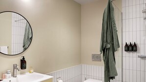 Un bany amb vàter, rentapel, mirall i dutxa.