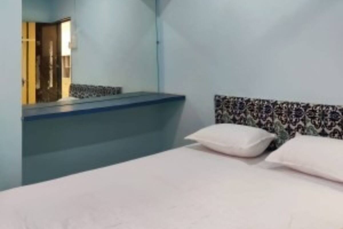 Ein Schlafzimmer mit einem Bett, einem Schminktisch und einem Spiegel.