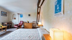 Un dormitorio con cama, muebles de madera, un escritorio, una silla y una lámpara.