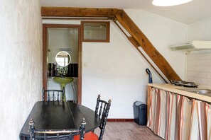 A kitchen with a dining table, chairs, a window, and a sink.