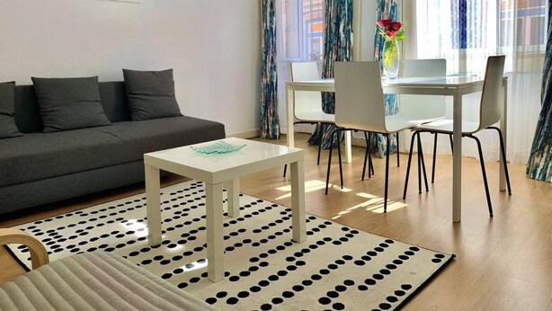 A modern living room with a grey sofa, a white coffee table, and a patterned rug. - Central Avenue #2 (Lisboa)