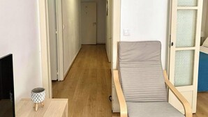 A compact room with a single bed, a small table with a decorative item, and a television on a stand. - Central Avenue #2 (Lisboa)
