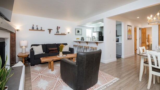 Ein modernes Wohnzimmer mit einer Couch, einem Couchtisch und einem Essbereich mit Stühlen und einem Tisch.