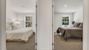 A bedroom with two beds, a window, and a door. - Welcoming 3-bedroom home with jacuzzi (Winterport)