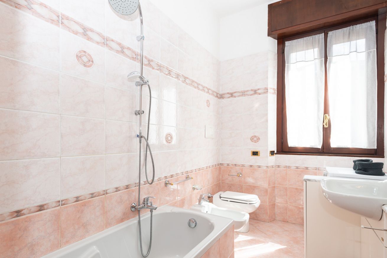 A bathroom with a bathtub, toilet, and sink.