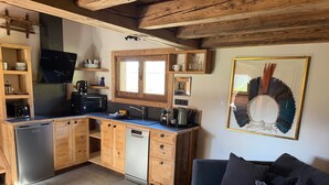 A compact kitchen with wooden cabinets, a dishwasher, and a coffee maker. - Chalet “Mazot De La Pointe Percée” with Balcony (Combloux)