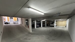 A multi-level parking garage with concrete floors and white pillars. - Borgo di Levante Apt1 (Brindisi)