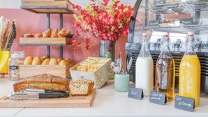 Una vitrina de panadería con pasteles, pan y bebidas.