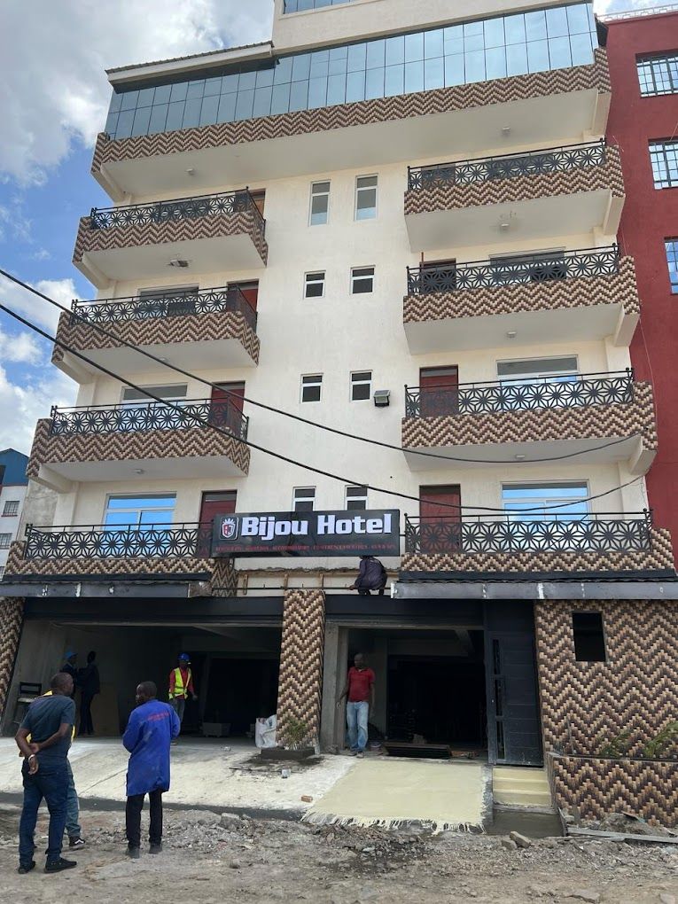 Un hôtel avec une enseigne indiquant « Bijou Hotel » et une façade ornée de motifs.