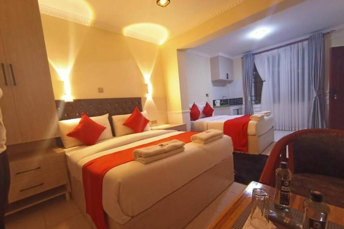 Una habitación de hotel con dos camas, un comedor y una kitchenette.