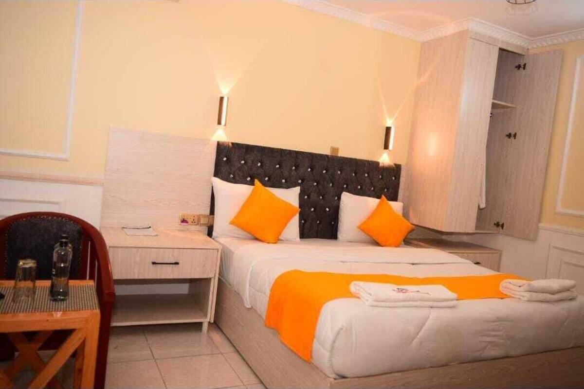 Una habitación de hotel con cama, mesitas de noche, escritorio y silla.