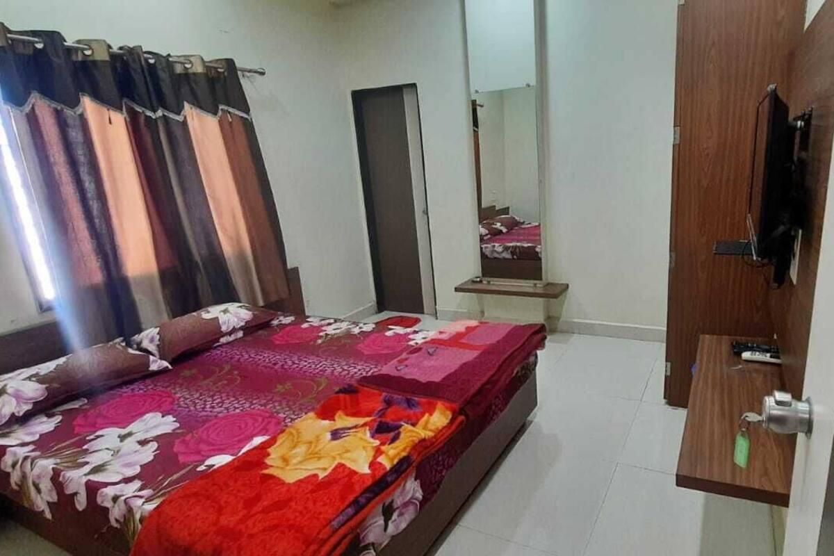Ein Schlafzimmer mit einem Bett, einem Holzschrank, einem Spiegel und einem kleinen Tisch.