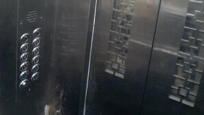 L’intérieur d’un ascenseur, avec un écran numérique affichant le chiffre 2, un clavier et une porte métallique dotée d’une poignée.