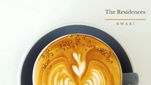 Uma chávena de café com arte de latte sobre um pires azul escuro.