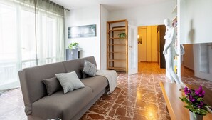 Una sala de estar moderna con un sofá, un maniquí y una estantería.