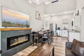 A modern kitchen with white cabinetry, a built-in oven, and a stainless steel refrigerator.