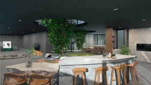 A modern interior with a central bar area, seating arrangements, and a large indoor plant.