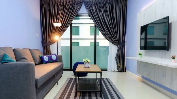 A modern living room with a sofa, a coffee table, and a TV mounted on the wall. - Cozy JB Suasana 15 Suite, City Views (Johor Bahru)