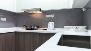 Een moderne keuken met een ingebouwde oven, een waterkoker en een koffiezetapparaat op het aanrecht.
