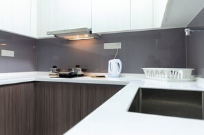 Eine moderne Küche mit einem eingebauten Backofen, einem Wasserkocher und einer Kaffeemaschine auf der Arbeitsfläche.