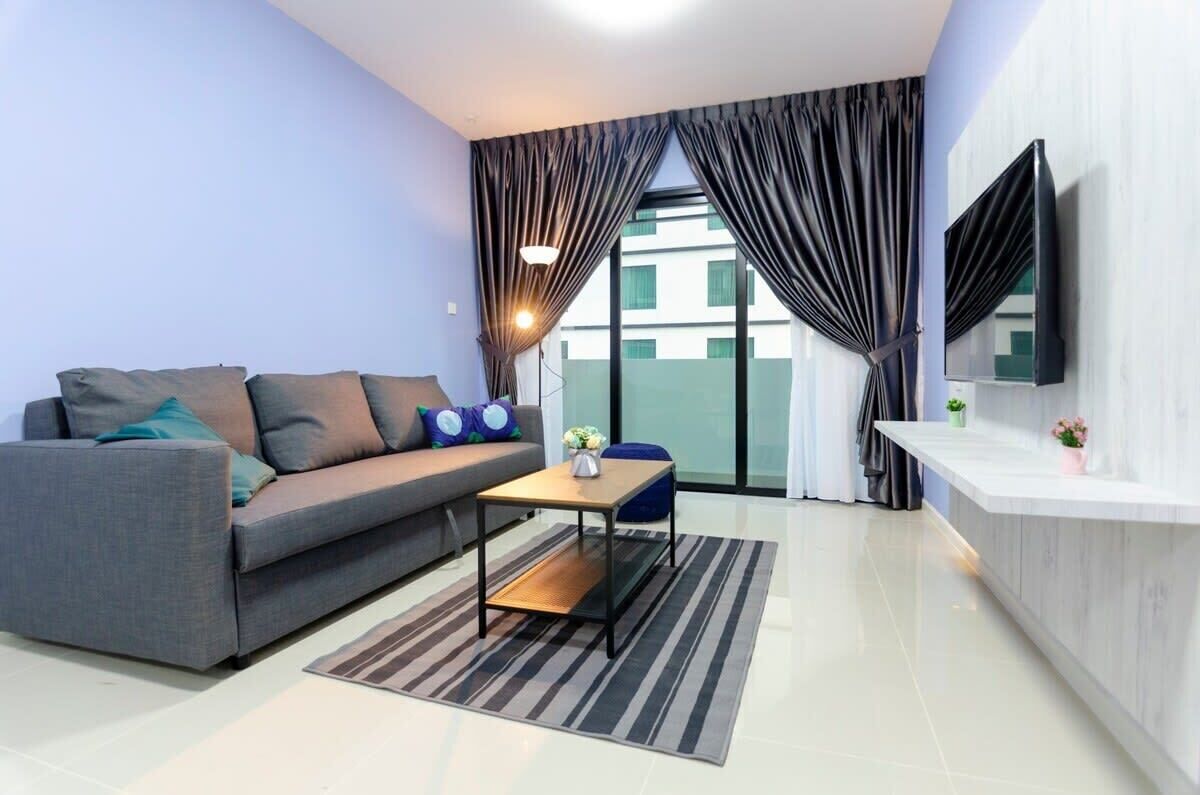 A modern living room with a grey sofa, a small wooden coffee table, and a striped rug.
