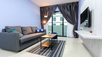 A modern living room with a grey sofa, a small wooden coffee table, and a striped rug.