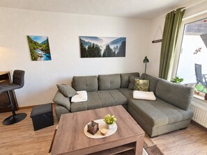 Una sala de estar moderna con un sofá modular, una mesita de centro y dos cuadros colgados en la pared.