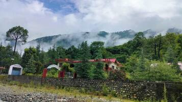 A rural setting with a stone wall, a small building with a red roof, and a sign that reads "Hotel."