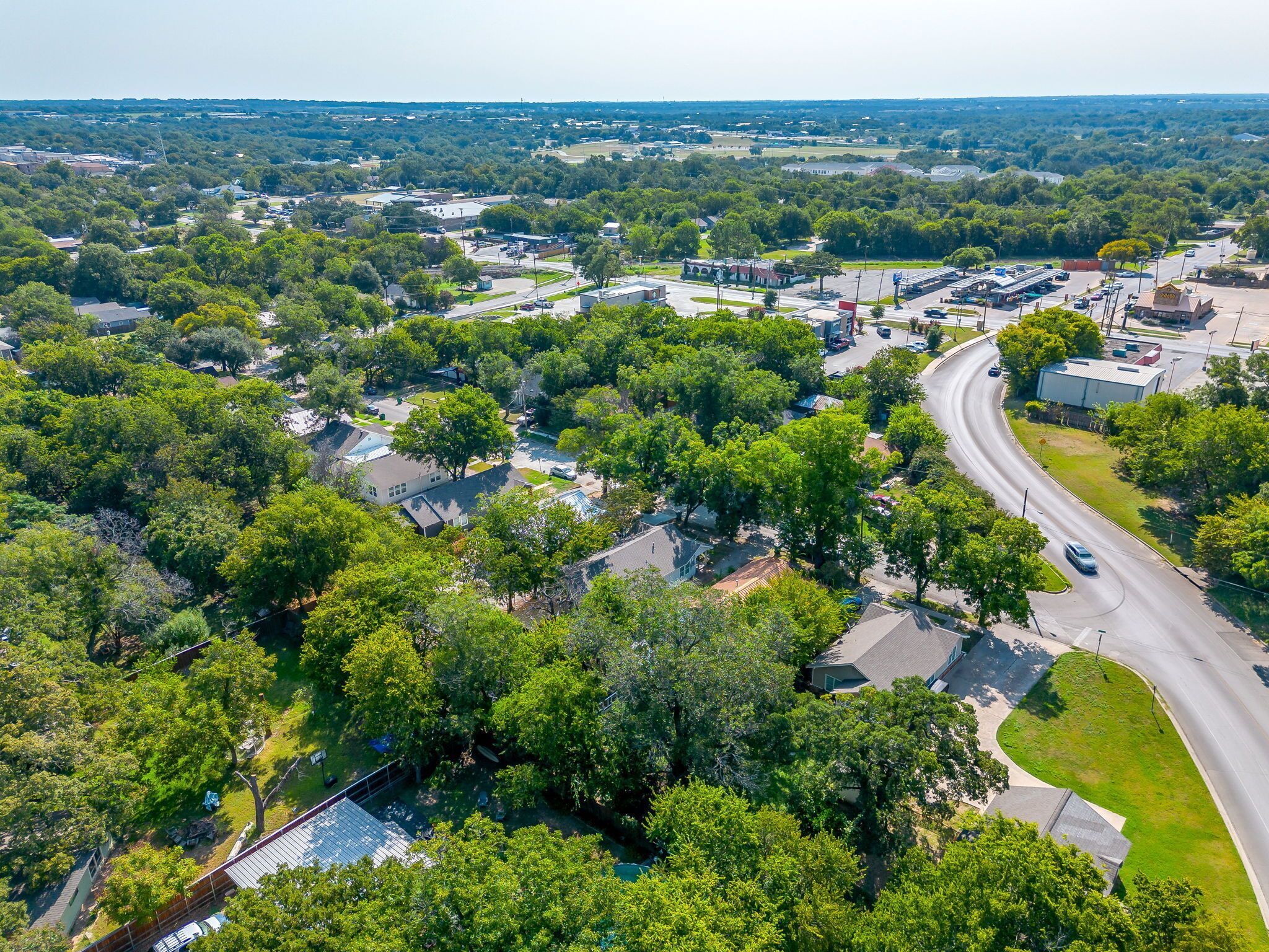 Vista aérea de una zona residencial con casas, carreteras y un gran complejo de edificios.