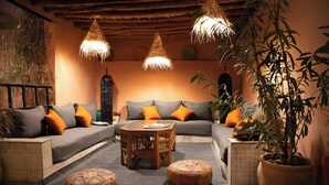 Ein gemütliches Wohnzimmer mit einer Couch, Hockern, einem Couchtisch und Pendelleuchten.