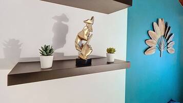 Un interior moderno con dos estantes flotantes color café oscuro, cada uno con objetos decorativos y pequeñas macetas.