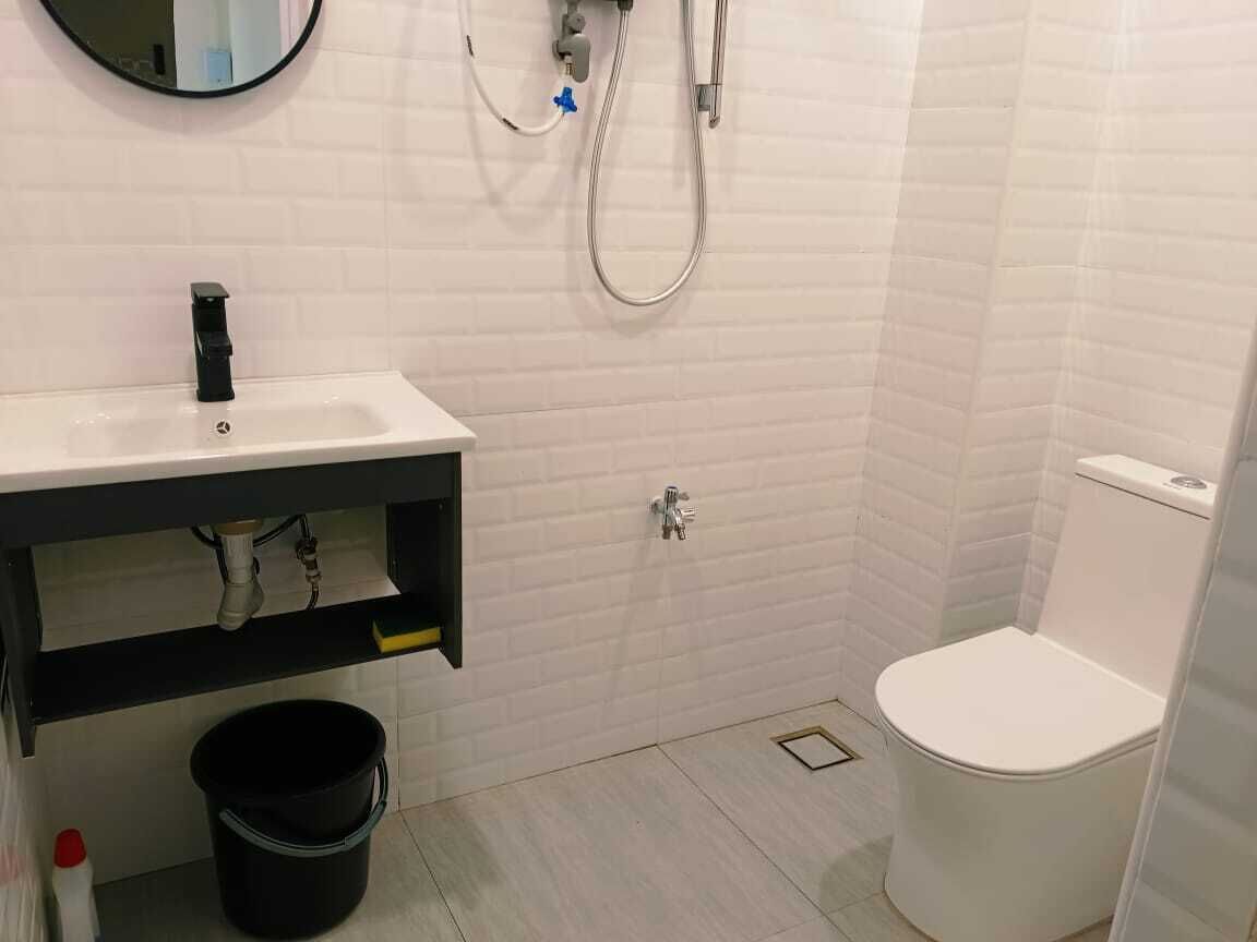 A bathroom with a white sink, a toilet, and a shower area.