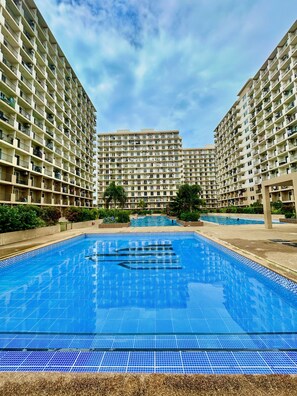 A large swimming pool surrounded by high-rise residential buildings. - Studio Retreat with Balcony and Pool (Lapu-Lapu)