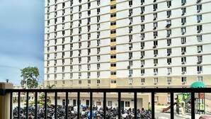Un tablero de ajedrez en un balcón con vista a un estacionamiento y un edificio al fondo.