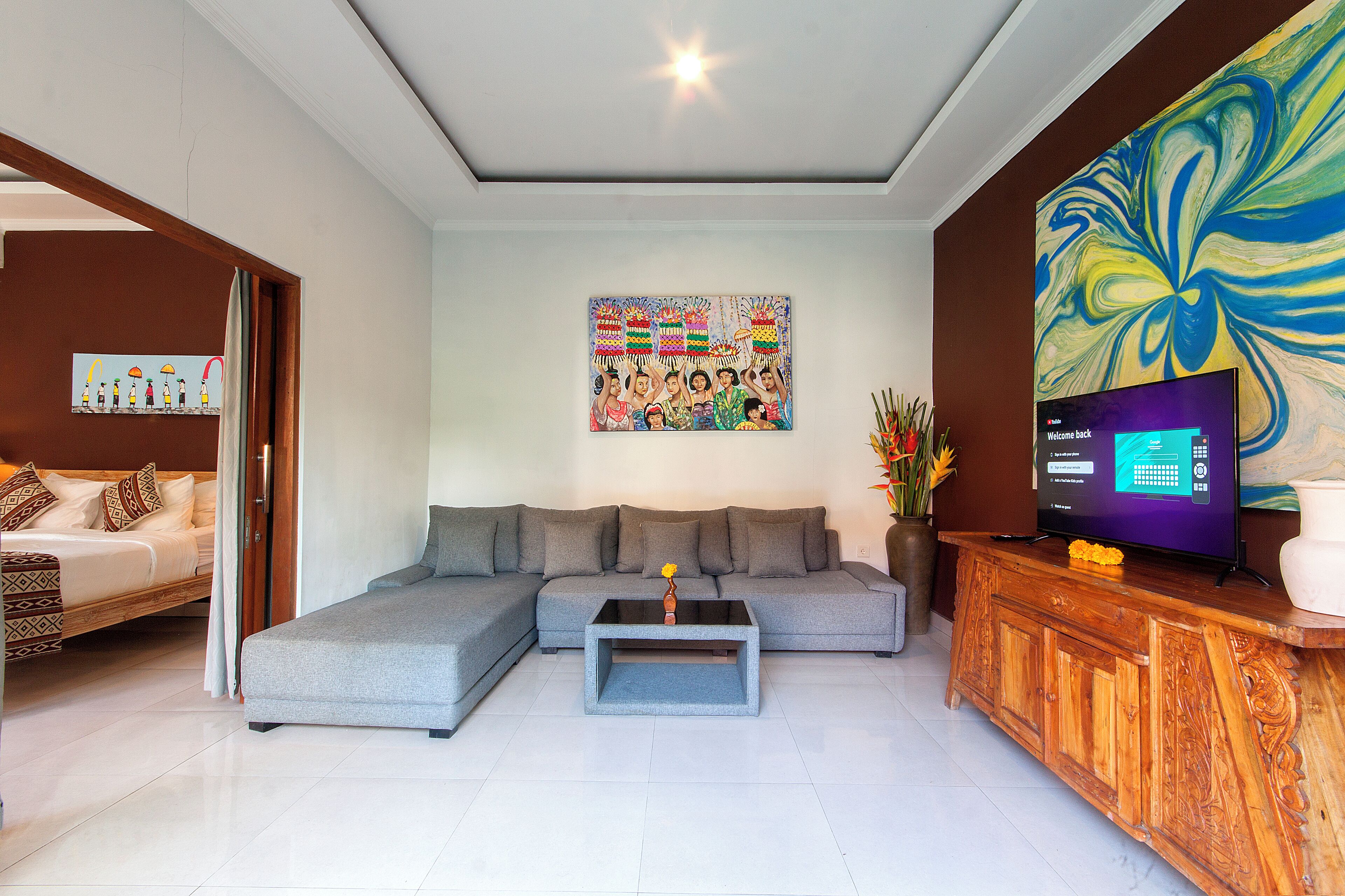 A modern living room with a grey sectional sofa, a wooden coffee table, and a large abstract painting.