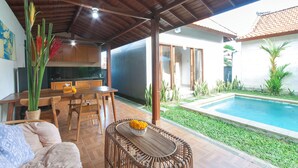 A covered patio with a pool, wooden furniture, and a dining area. - Tranquil Maha Villa Ubud (Ubud)