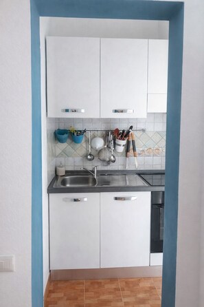 Een koelkast, een oven, een kookplaat, een koffiezetapparaat/waterkoker