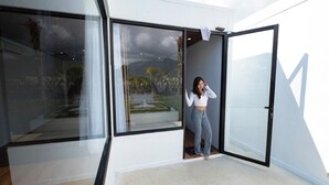 A modern interior with large glass doors leading to a patio area. - Lake Batur Villa (Kintamani)