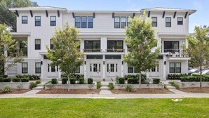 A modern multi-story building with a symmetrical facade, large windows, and a central entrance. - Sincerely Shem III- 7 min to beach and dtwn CHS (Mount Pleasant)