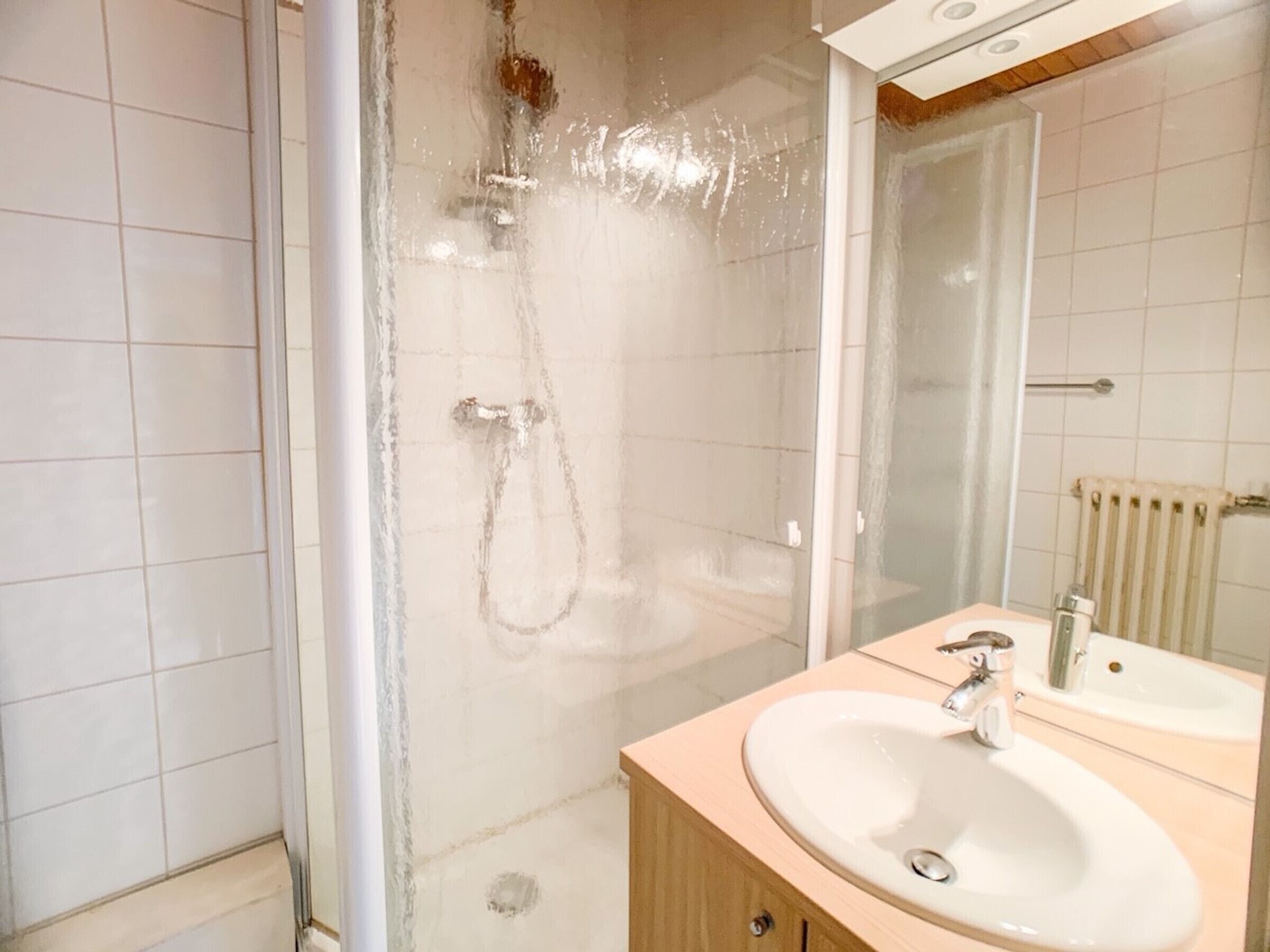 A bathroom with a shower, a sink, and a mirror.