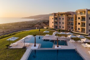 A modern hotel with a pool area, multiple balconies, and a view of the sea. - Radisson Residences Taghazout Bay (Taghazout)