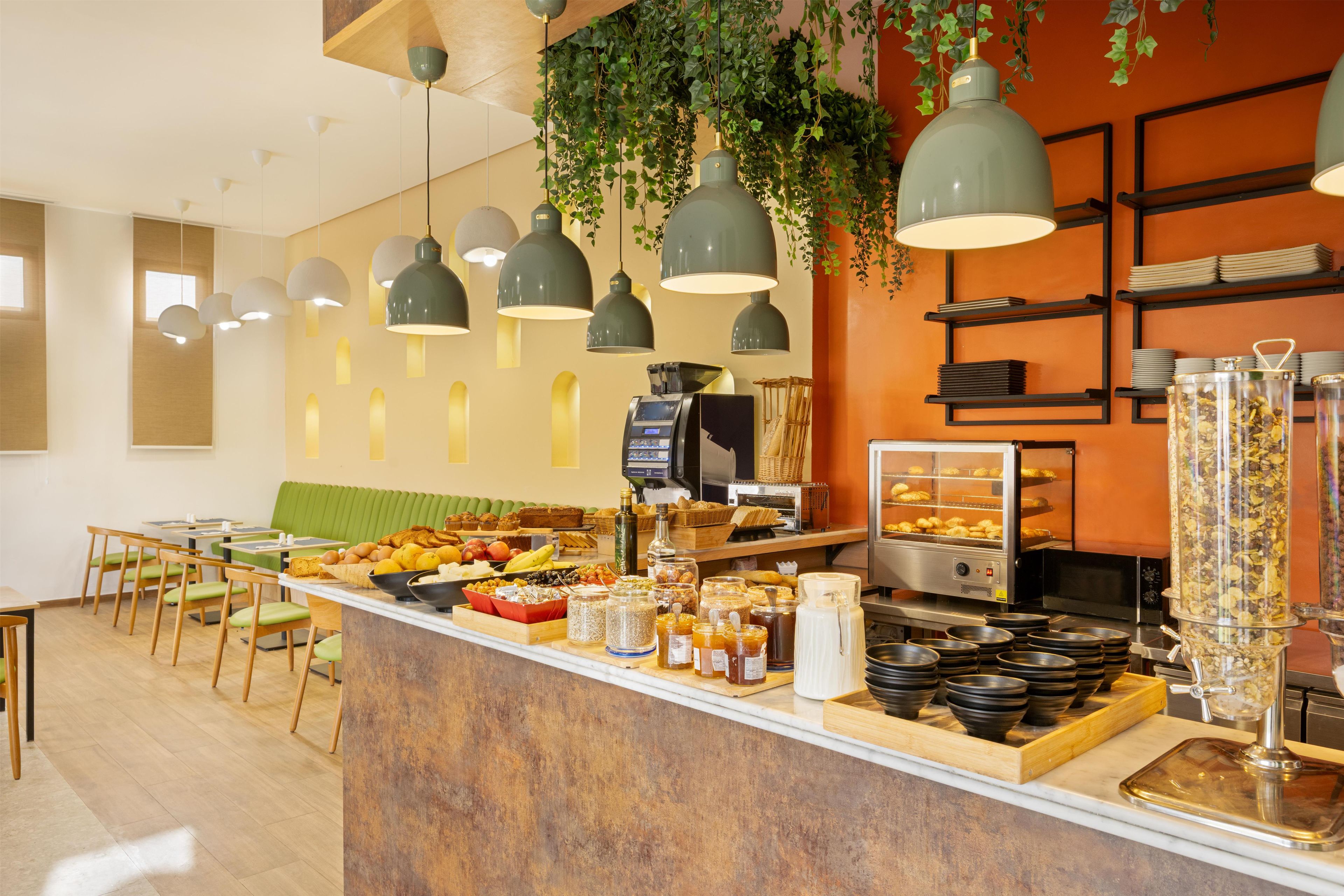 Un bufé de desayuno con diferentes alimentos y una máquina de café.
