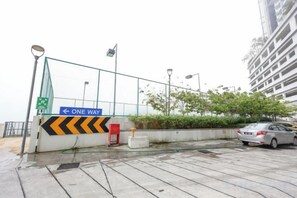 Ein Parkplatz mit einem Einbahnzeichen, einem roten Hydranten und einem Gebäude im Hintergrund.