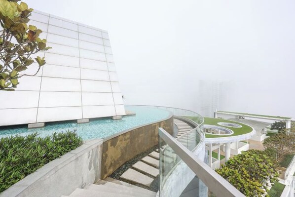 Un bâtiment moderne doté d’une piscine, d’un escalier en colimaçon et d’un jardin sur le toit végétalisé.