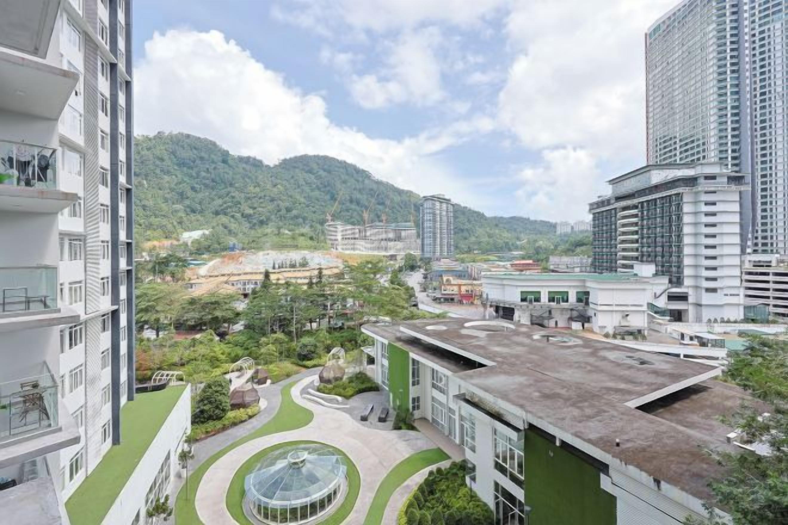 A high-rise building with a rooftop garden and a view of a mountainous area.