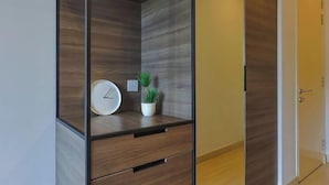 A modern room with a built-in wooden cabinet, a clock, and a small potted plant.